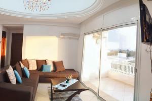 een woonkamer met een bank en een balkon bij 2 bedrooms apartement at Hammamet 100 m away from the beach with sea view shared pool and balcony in Hammamet