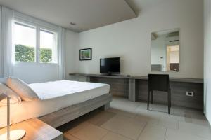 a bedroom with a bed and a desk with a television at Locanda La Gazzella in Maranello