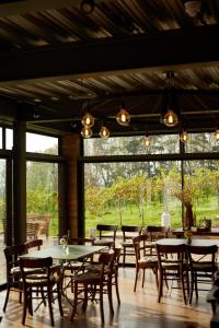 - une salle à manger avec des tables, des chaises et de grandes fenêtres dans l'établissement The Old Winery Cottage No2, à Shepton Mallet