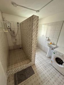 a bathroom with a shower and a washing machine at Big & confortable house in Oxford street Barnor in Accra