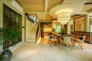 une salle à manger avec une table et des chaises et un escalier dans l'établissement The Ubāri Bali - Luxury Riverside Escape, à Ubud