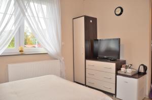 a bedroom with a bed and a tv on a dresser at Pokoje Gościnne Mizera in Kudowa-Zdrój