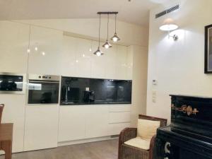 a kitchen with white cabinets and a piano at 2 bedrooms apartement with lake view furnished balcony and wifi at Porto in Porto