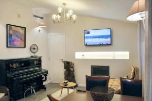 uma sala de estar com um piano e uma televisão na parede em 2 bedrooms apartement with lake view furnished balcony and wifi at Porto no Porto