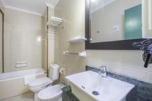 een badkamer met een wastafel, een toilet en een spiegel bij Itaca Colón by Soho Boutique in Córdoba