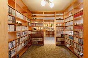 una biblioteca con estanterías de madera y libros en Matsumoto Tourist Hotel, en Matsumoto