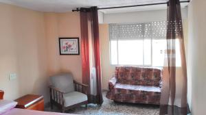 a bedroom with a chair and a window with a chair at 2 bedrooms apartement with city view and furnished balcony at Guardamar del Segura 1 km away from the beach in Guardamar del Segura