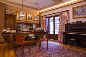 ein Wohnzimmer mit einem Schreibtisch und einem Klavier in der Unterkunft Hotel Pilier D'Angle & Wellness in Courmayeur