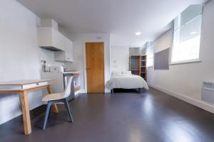 For Students Only Ensuite Bedrooms with Shared Kitchen and Studios at The Old Fire Station in Birmingham في برمنغهام: مطبخ مع مكتب وسرير في غرفة