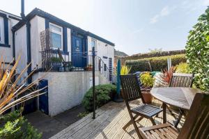 a patio with a table and chairs on a deck at McHoppity House - Crail in Crail