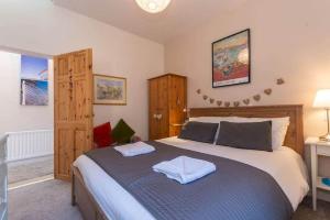 a bedroom with a large bed with two towels on it at McHoppity House Crail, Sleeps 6, Free Parking in Crail