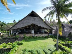 an exterior view of a house with a palm tree at Mafía Island Lodge in Utende