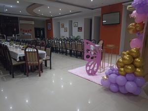 a banquet hall with a table with purple and gold balloons at Hotel Oasis in Heroica Caborca