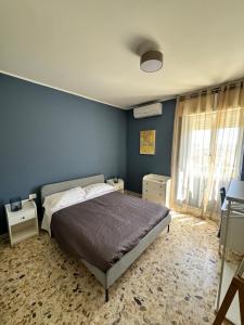 een slaapkamer met een bed en een blauwe muur bij HS Easy holiday home in Latina