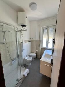 een badkamer met een douche, een toilet en een wastafel bij HS Easy holiday home in Latina