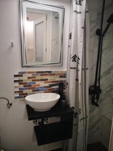 W łazience znajduje się umywalka i lustro. w obiekcie Chic Studio in Old Town w Sybinie