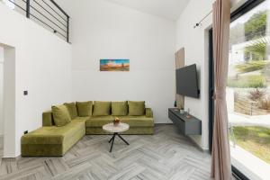 ein Wohnzimmer mit einem Sofa und einem TV in der Unterkunft Rajska dolina Budva in Boreti