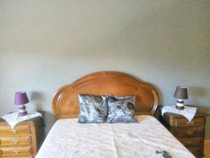 una camera con letto in legno e 2 comodini di 2 bedrooms apartement with enclosed garden and wifi at Urqueira a Urqueira