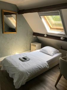 a bedroom with a bed with a mirror and a window at de Zeilende kraay in Katwijk