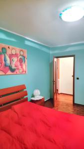 - une chambre avec un lit rouge et un mur bleu dans l'établissement One bedroom apartement with balcony at Villastellone, à Villastellone