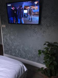Katwijk的住宿－de Zeilende kraay，挂在墙上的平面电视