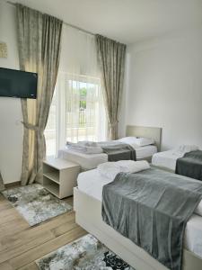 a room with four beds and a tv and a window at Adriana Touristik Hostel 3 Stele Arad in Arad +36 photos