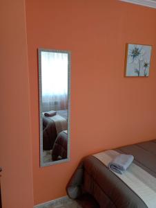 uno specchio in una camera da letto con parete arancione di A Casa do San Paio de Buscás a Ordes