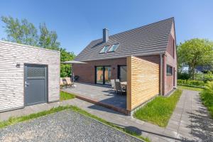 ein Backsteinhaus mit einem Innenhof und einer Terrasse in der Unterkunft Risum Huus in Risum-Lindholm