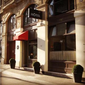 a hotel with potted plants in front of a building at Hôtel Victoria Châtelet in Paris