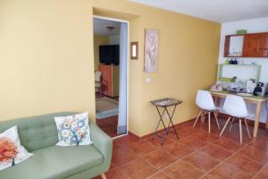 a living room with a couch and a table and a kitchen at One bedroom apartement with furnished garden and wifi at Collado Villalba in Collado-Villalba