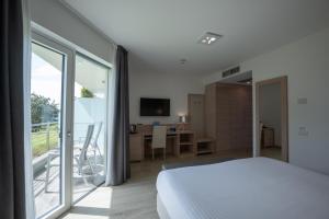 Schlafzimmer mit einem Bett und einer Glasschiebetür in der Unterkunft Hotel Bellariva in Riva del Garda
