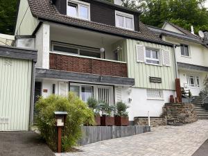 uma casa branca com um telhado castanho em Apartment,Wohnung & Zimmer 'Am Waldfreibad' em Much