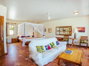 een woonkamer met een witte bank en een bed bij Flamboyant Diani Beach in Diani Beach