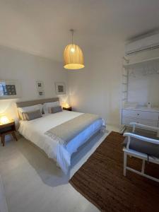Un dormitorio con una gran cama blanca y una lámpara en House with a view en Alcácer do Sal
