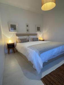 ein Schlafzimmer mit einem großen weißen Bett mit zwei Lampen in der Unterkunft House with a view in Alcácer do Sal