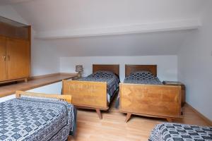 3 camas en una habitación con paredes blancas y suelo de madera en ApartHotel François 1er 14eme, en Vitry-le-François