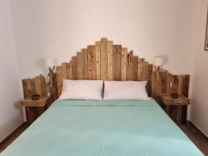1 cama con cabecero de madera en una habitación en Résidence Le Village Marin, en Porto Vecchio