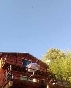 a building with an umbrella on a balcony at Chalé No Mundo da Lua in Piedade