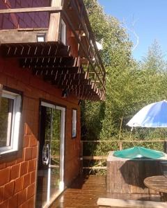a patio with a table and an umbrella next to a building at Chalé No Mundo da Lua in Piedade +14 photos