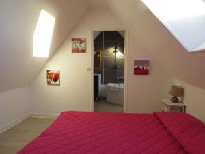 1 dormitorio con cama roja y baño en ApartHotel François 1er - 16ème, en Vitry-le-François