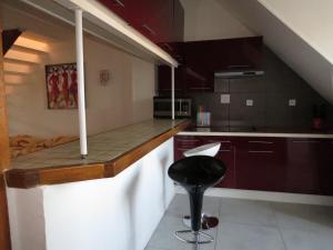 a kitchen with a bar with a stool in it at ApartHotel François 1er - 16ème in Vitry-le-François