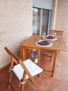 a wooden table with two plates and two chairs at 2 bedrooms apartement with shared pool and terrace at Ciruena in Cirueña