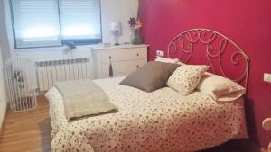 a bedroom with a bed with a pink wall at 2 bedrooms apartement with shared pool and terrace at Ciruena in Cirueña