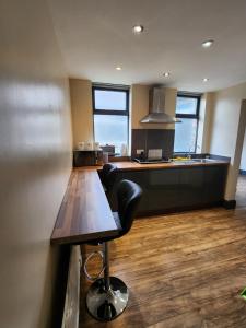 a kitchen with a wooden table and a counter top at 133B PARK ROAD STRETFORD MANCHESTER in Manchester