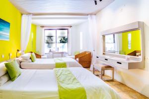 2 camas en una habitación con paredes amarillas en Flamboyant Diani Beach en Diani Beach