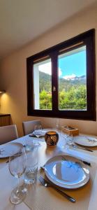 a table with glasses and plates on it with a window at Mont de Grange - Châtel - Alp'in C in Châtel +6 photos