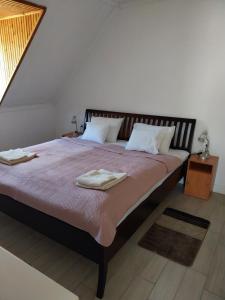 a bedroom with a large bed with two towels on it at Pipacs Vendégház in Bogács