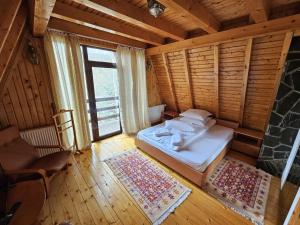 1 dormitorio con 1 cama en una habitación de madera en Casa Edenland Doftana, en Trăisteni