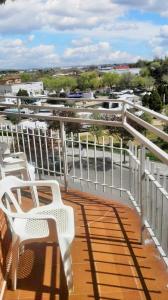 uma varanda com cadeiras brancas e vista para um porto em 3 bedrooms apartement with furnished terrace and wifi at Navalcarnero 5 km away from the slopes em Navalcarnero