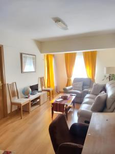 uma sala de estar com um sofá e uma mesa em 3 bedrooms apartement with furnished terrace and wifi at Navalcarnero 5 km away from the slopes em Navalcarnero